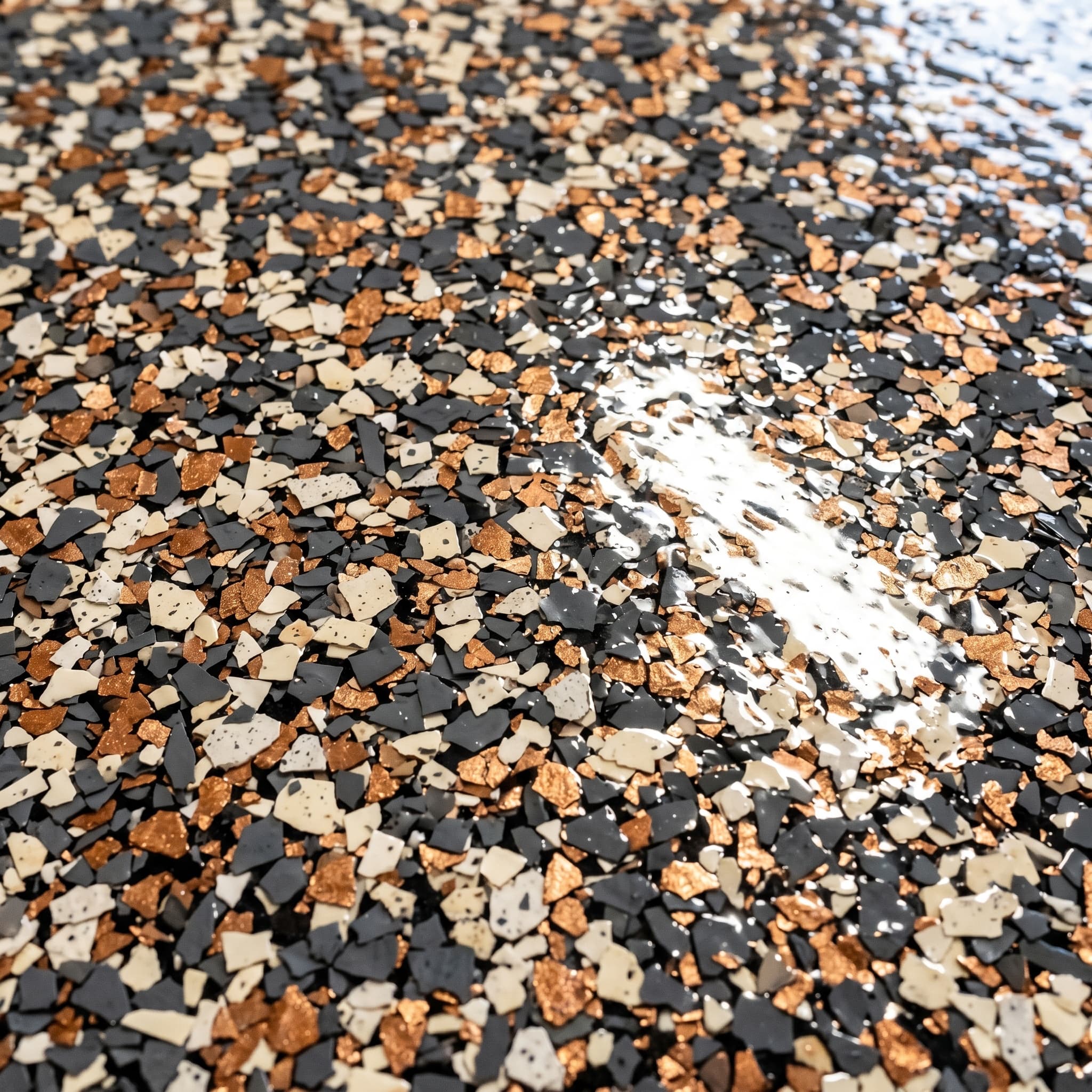 Macro of dense flake floor under polyaspartic, charcoal cream copper.