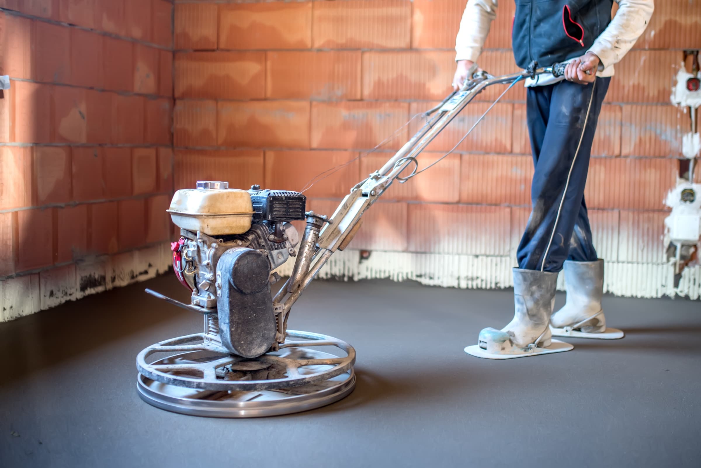 Power trowel finishing a smooth epoxy-ready concrete surface.