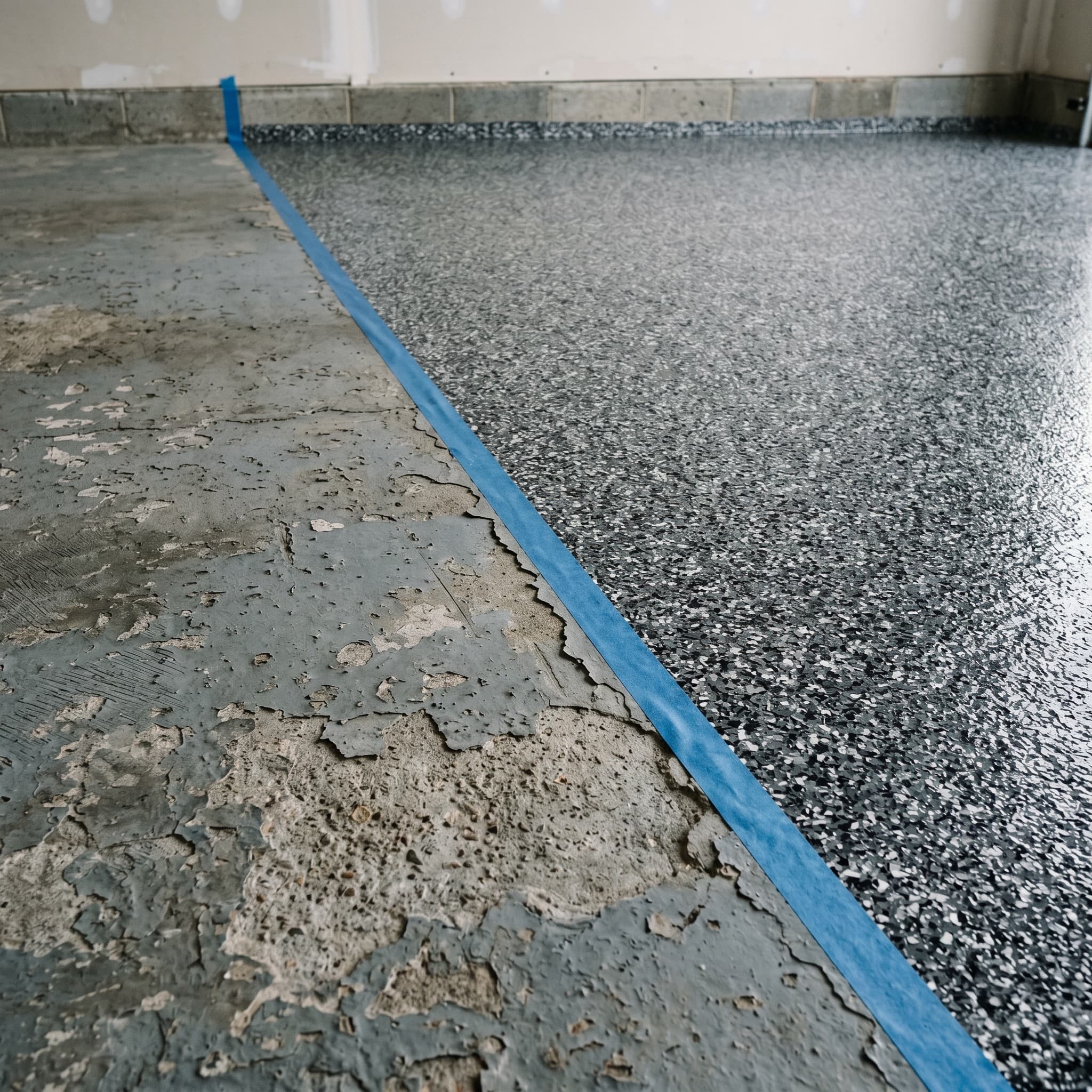 Half a Troy garage floor: failed coating beside fresh recoat.