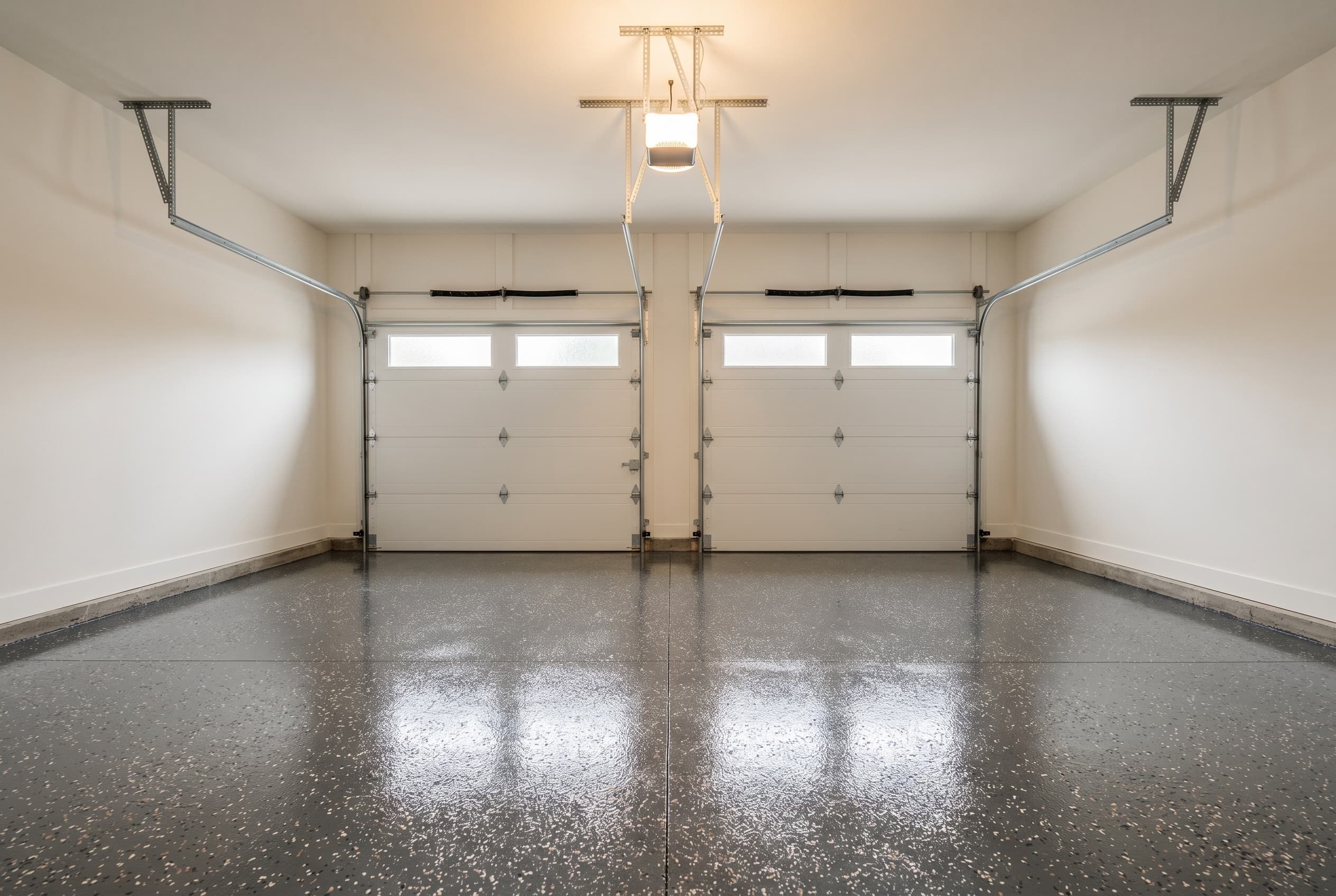 Wide finished two-car Troy garage with charcoal flake epoxy.